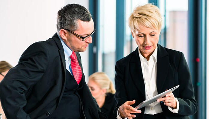 GRE Verbal Strategy Discussion Two professionals reviewing documents, representing strategic GRE Verbal preparation.