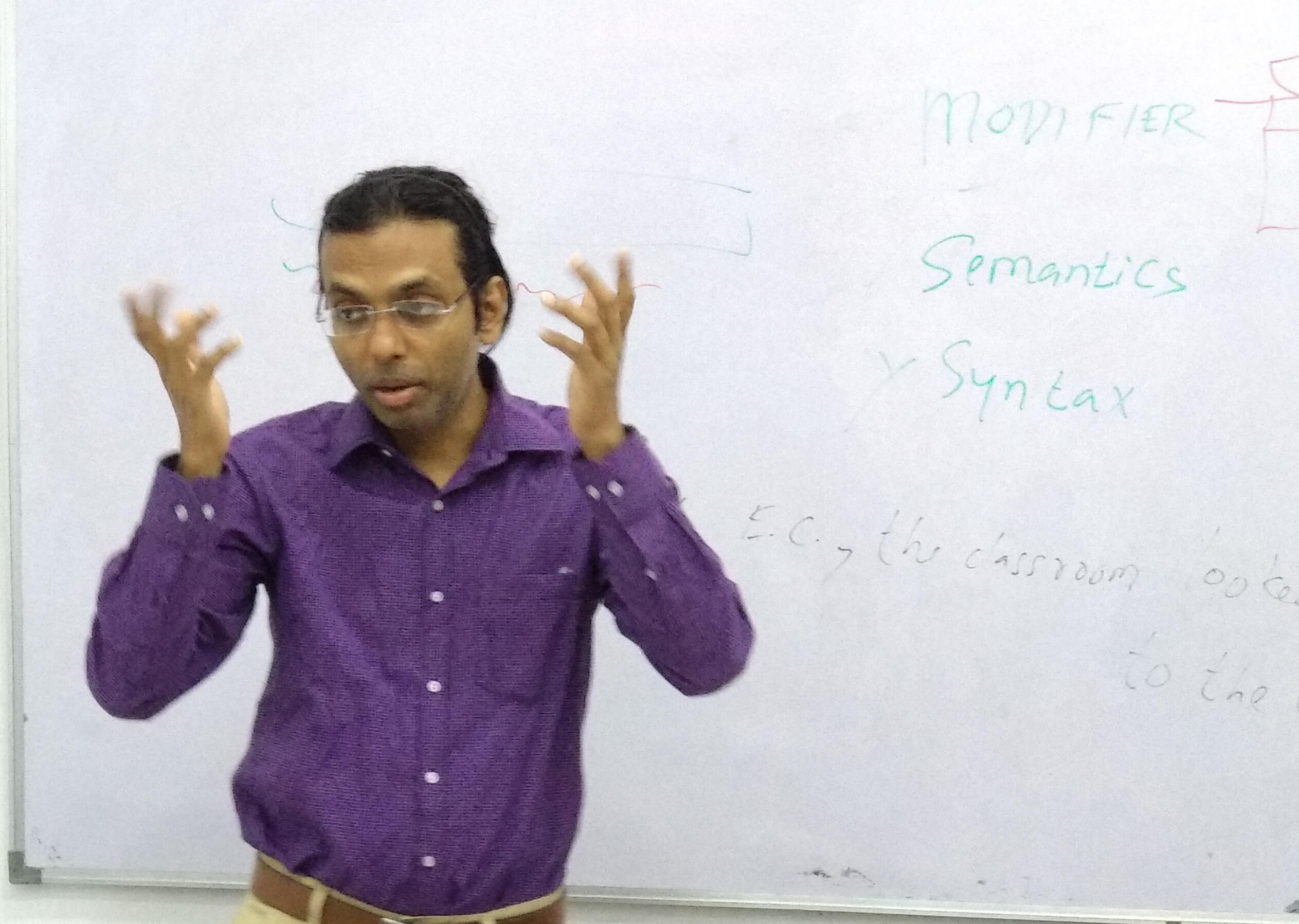 Neelesh Kumar Ray Teaching Verbal Reasoning Neelesh Kumar Ray teaching verbal reasoning in a classroom with a whiteboard behind him.