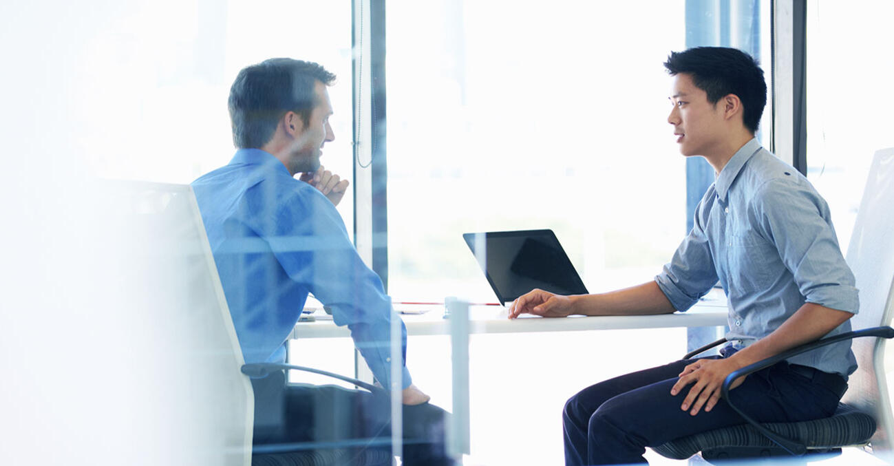 GRE Verbal Skill-Building Session Two people discussing strategy in an office, representing GRE Verbal skill-building.